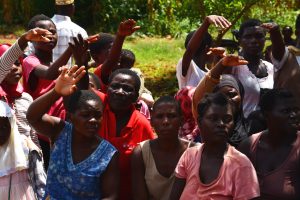 A group of Malawians, mainly womne, raising their hands