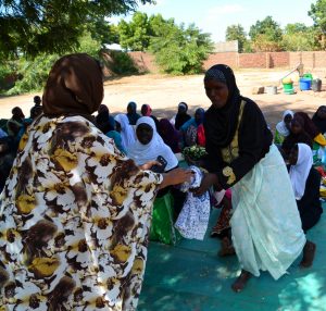 Woman being given a prize as part of a HIV quiz, Nchalo, Malawi